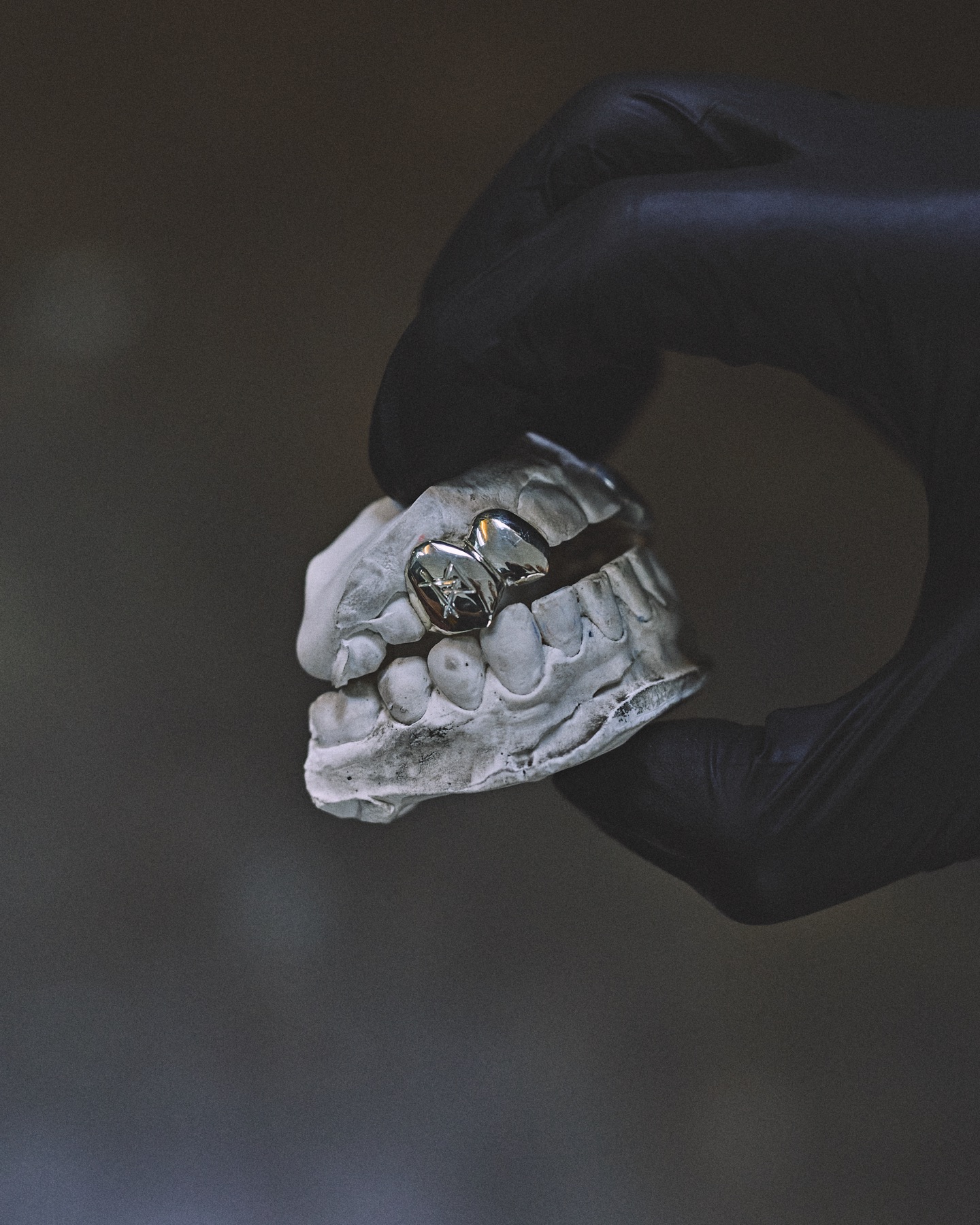 Détail d'un grillz en argent façonné à la main à l'établi de l'atelier