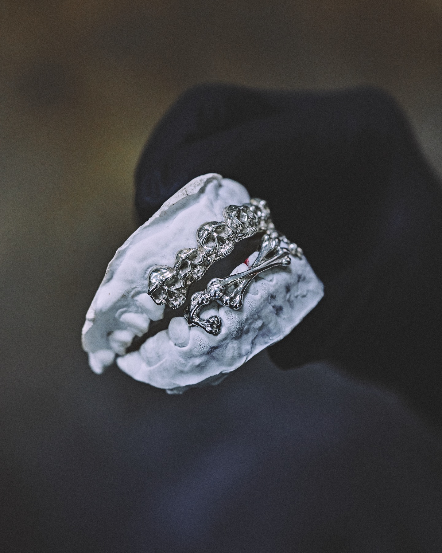 Grillz en argent sculpté de têtes de mort et d'ossements