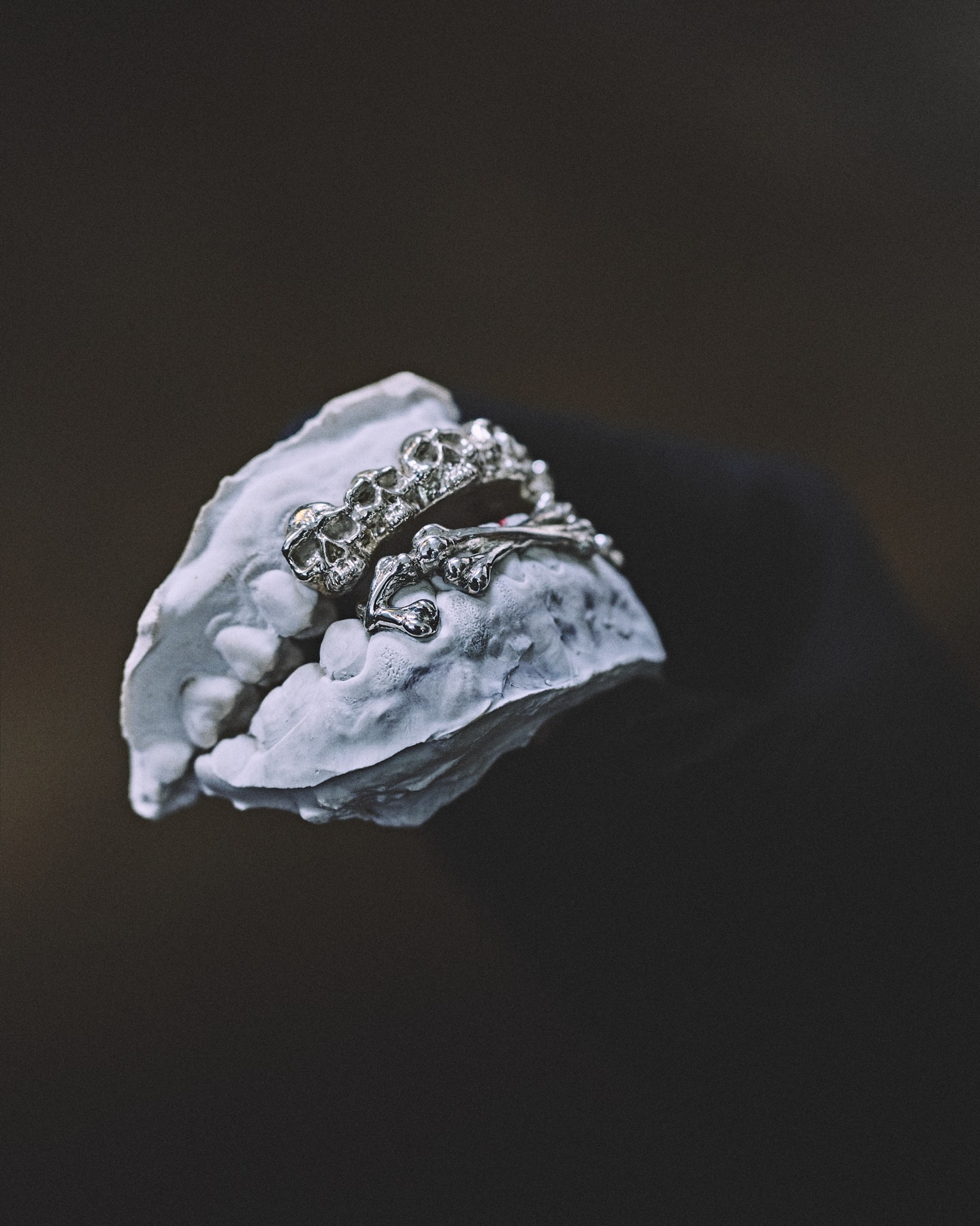 Détail sculpté d'un grillz argent, ciselure à la loupe